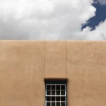 Fenêtre sur mur en stuc avec fond de ciel nuageux