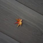 Feuille d'érable orange sur sol en bois gris