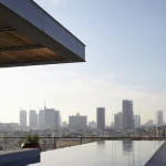 Vue panoramique d'une ville moderne depuis une terrasse avec piscine