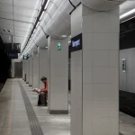 Personne lisant dans une station de métro déserte