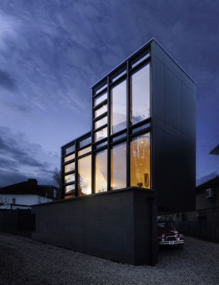 Maison moderne avec grande façade vitrée au crépuscule