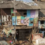 Maison faite de tôle ondulée colorée avec enseigne de bienvenue