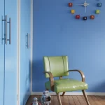 Salle bleue avec chaise verte et jouets robots