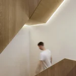 Homme descendant un escalier moderne en bois