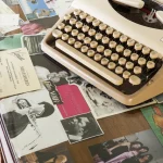 Machine à écrire vintage sur un bureau avec photos et tickets.
