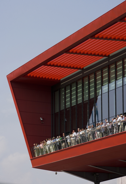 AKG5391623.webp Groupe de personnes sur une terrasse moderne rouge – Image 1