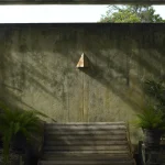 Banc dans un patio ensoleillé avec murs en béton