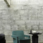 Fauteuil vert et table d'appoint dans un intérieur en béton