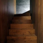 Escalier en bois menant à un mur en briques