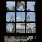 Vue à travers une fenêtre délabrée d'une structure historique.