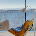 Fauteuil design face à la mer avec vue sur un pont