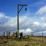 Paysage champêtre avec clôture en bois et ciel nuageux