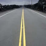 Route déserte sous un ciel nuageux