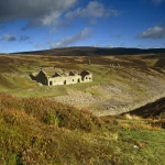 Ruines dans la vallée de montagnes sous un ciel bleu