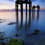 Structure Métallique Abandonnée au Bord de la Mer au Coucher du Soleil