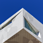 Bâtiment moderne avec façade géométrique et ciel bleu