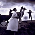 Femme élégante avec des lamas sous un ciel orageux