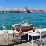 Table de café au bord de l'eau avec vue sur une ville européenne