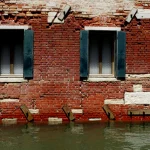 Façade de Brique Inondée avec Volets Fermeés