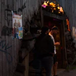 Deux hommes devant un bâtiment délabré avec des affiches