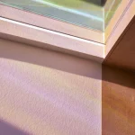 Reflet de la lumière du soleil sur mur texturé près d'une fenêtre