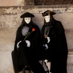 Masques vénitiens traditionnels devant un mur ancien