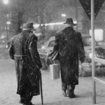 Deux hommes marchant sous la neige en ville
