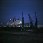 Bateau de croisière accosté dans un port industriel de nuit