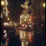 Rue nocturne asiatique avec néons et voitures anciennes sous la pluie