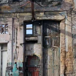 Vieille façade de bâtiment délabré avec porte et fenêtres abîmées