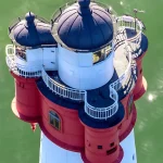 Vue aérienne d'un phare coloré surplombant la mer