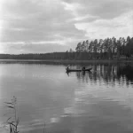 Personnes dans un bateau sur un lac calme en forêt