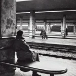 Gare ferroviaire déserte avec passagers en attente de train