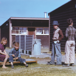 Enfants jouant devant des cabanes en bois