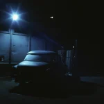 Voiture ancienne abandonnée sous lampe de rue