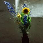 Bouquet de fleurs colorées dans un vase noir près d'une fenêtre en lumière douce