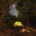 Tente de camping sous un ciel étoilé en forêt