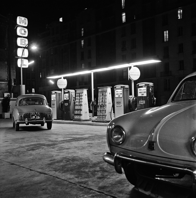 AKG5795967.webp Station-service Mobil en noir et blanc avec voitures classiques – Image 1