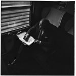 Homme faisant des mots croisés dans un train