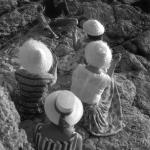 Groupe de personnes portant des chapeaux assis sur des rochers