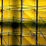 Échafaudage contre un mur jaune