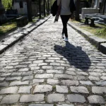 Femme marchant dans le cimetière ombragé