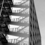 Escalier extérieur avec ombres projetées sur un bâtiment