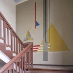 Escalier en bois avec fresque murale géométrique