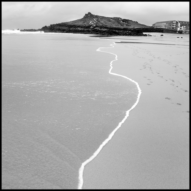 AKG6177242.webp Ligne de marée sur une plage avec maisons en arrière-plan – Image 1