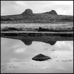 Reflection of Rocky Hills in a Tranquil Lake at Sunrise