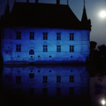 Château éclairé par la lune avec reflet dans l'eau