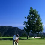 Golfeur se préparant à un putt sur un terrain de golf en montagne