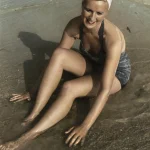 Femme assise sur la plage en maillot de bain