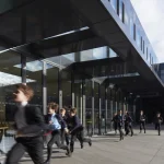 Enfants courant devant un bâtiment moderne